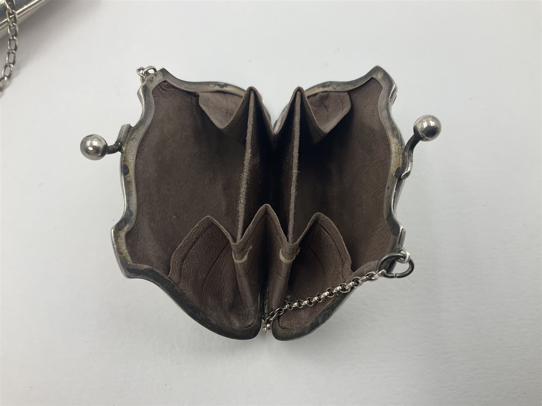 Early 20th century silver mounted coin purse, with leather interior and finger chain, hallmarked Samuel M Levi, Birmingham 1917, together with a similar Edwardian example, with engraved initials and engine turned decoration, hallmarked Birmingham 1907, maker's mark worn and indistinct, largest W11.3cm