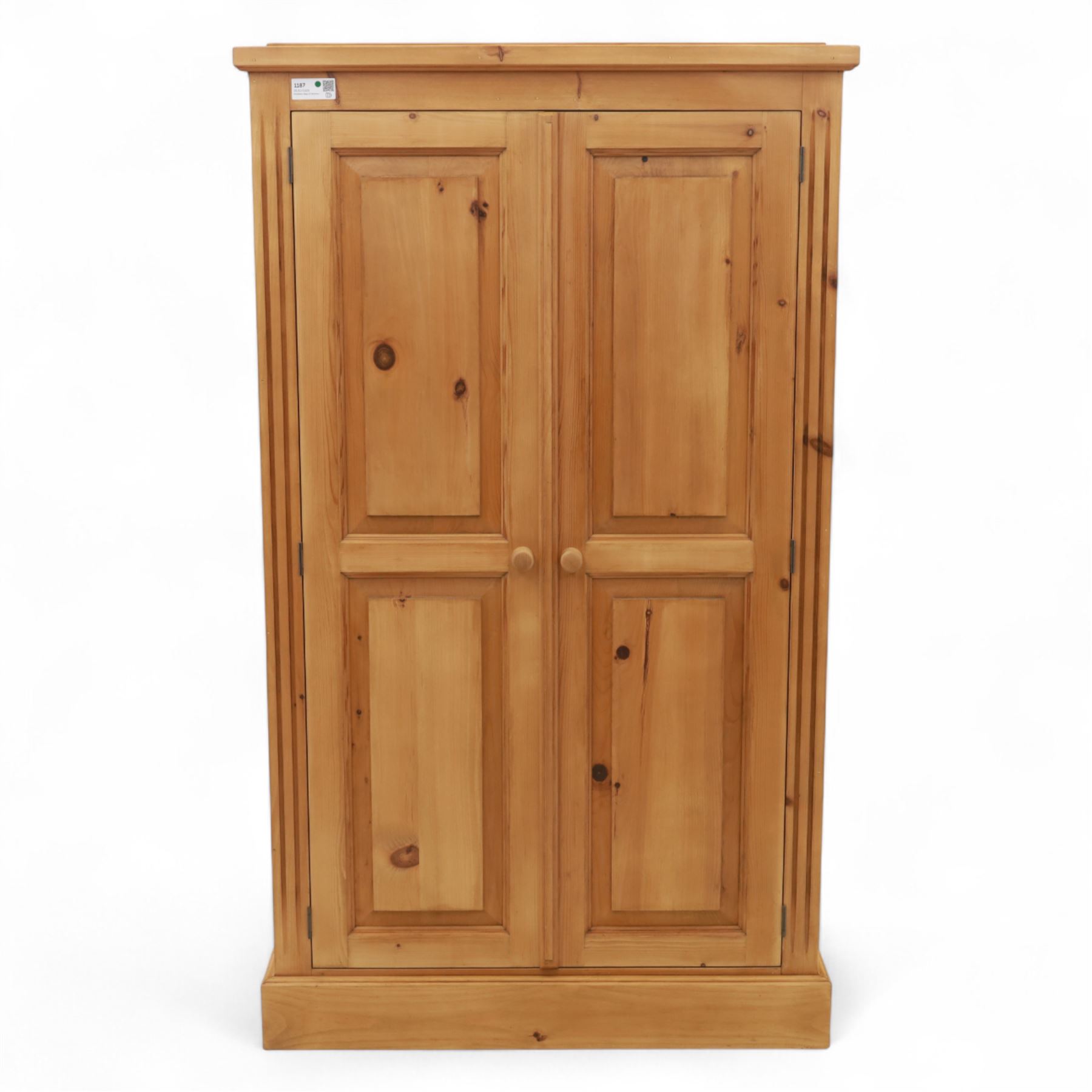 Modern stripped pine two-door wardrobe, the fielded panel doors with turned knob handles, opening to a double rail hanging interior, beneath a stepped cornice and raised on plinth base