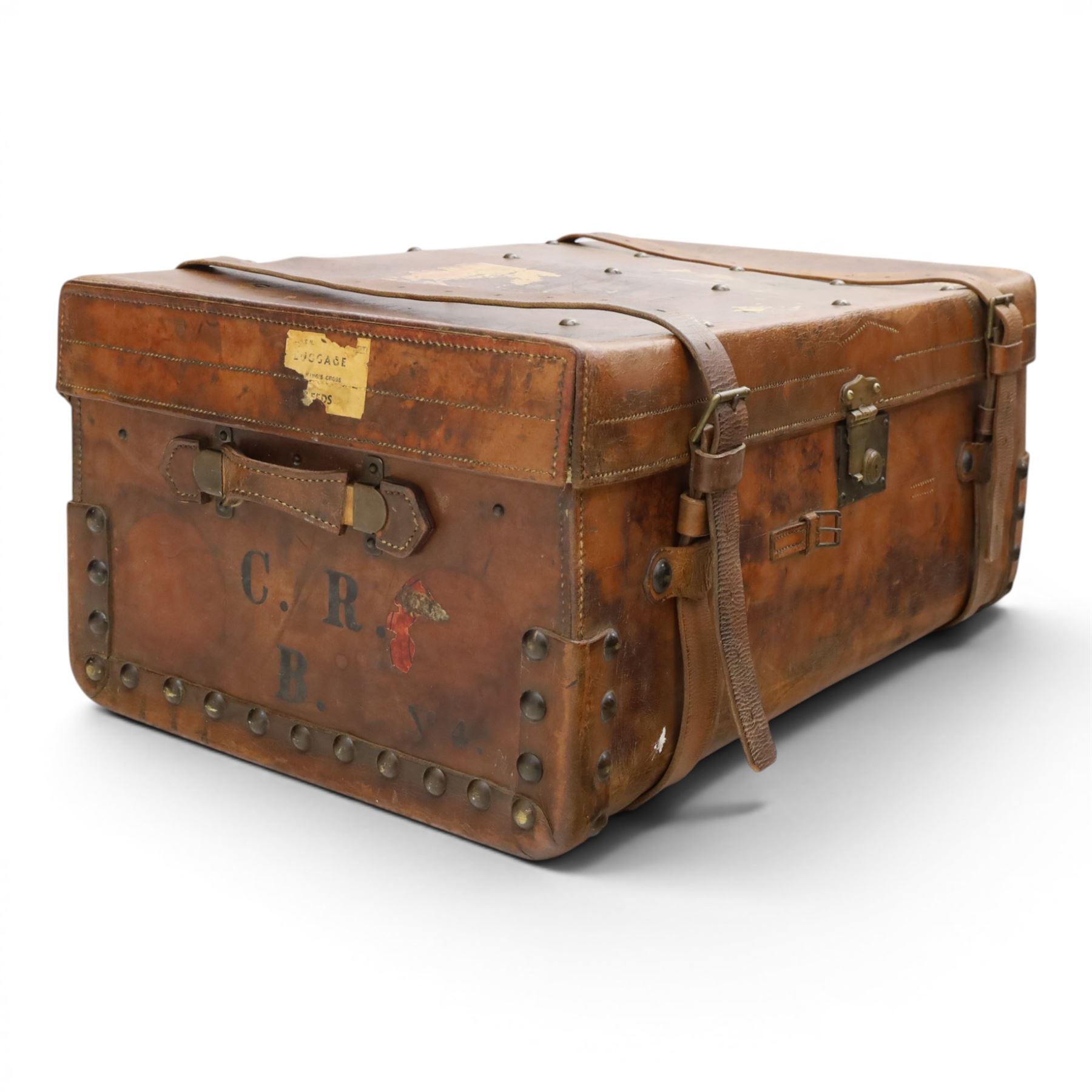 19th century leather trunk, featuring brass lock, with leather anchoring straps around the body, with leather handles