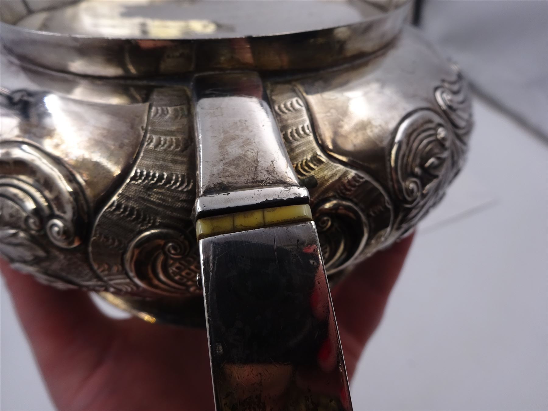 George III Irish silver teapot, of squat circular form, the body with repousse and chased floral and C scroll decoration, with capped C handle and ivory insulators, engraved to base 'Presented to Troop Sergeant Major John Percival, of the 4th Dragoon Guards by Alex D. Tait, Esq, late Captain in that corps as a mark of approbation of his steady and upright conduct when Sergeant Major of his Troop, Dublin, June 2nd 1843', hallmarked William Law, Dublin 1817, H12.5cm, This item has been registered for sale under Section 10 of the APHA Ivory Act