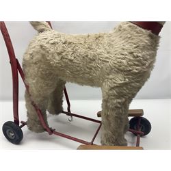 Tri ang - Pedigree Soft Toys - push along/ride-on dog as a wood wool filled plush Airedale terrier in red tubular frame with beech footrests and black rubber wheels; stitched Northern Ireland label in tact L60cm H61cm