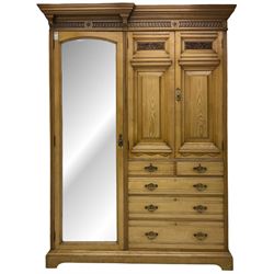 Late 19th century ash combination wardrobe, projecting cornice over foliage carved frieze, the left-hand upright enclosed by mirror glazed door, the right-hand side fitted with double panelled cupboard over two short and three long drawers, the upper panels carved with curled leaves and central scroll cartouche, on bracketed plinth 