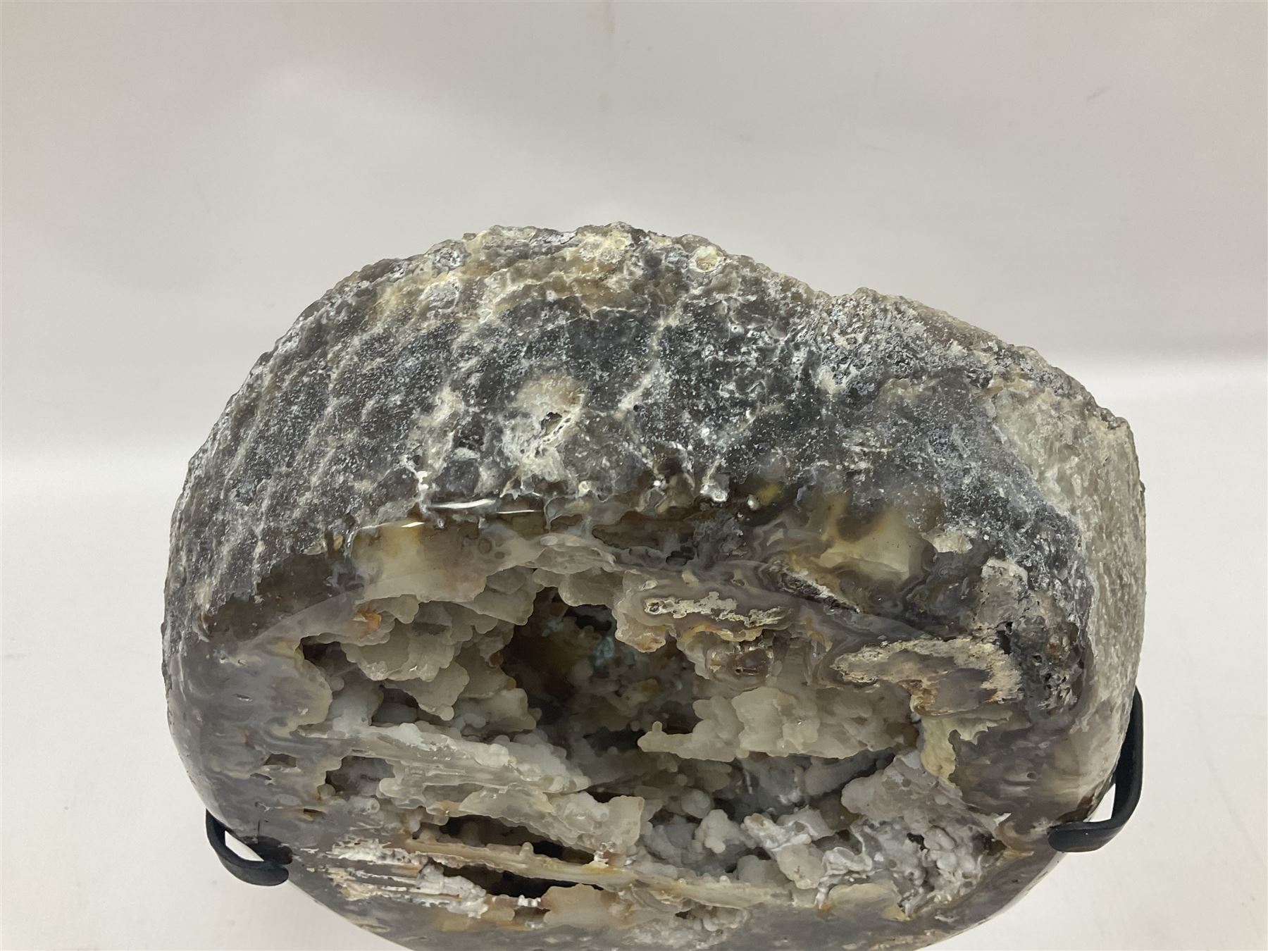 Large agate geode with quartz crystals to the centre, upon a metal stand, H35cm 