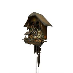 A 20th century West German 30-hour Automaton musical cuckoo clock with a Swiss musical movement playing three tunes, visible pendulum and three cast metal pine cone weights, carved pine wood case with automaton water wheel, woodsman and carousel, chapter ring with Roman numerals and decorative hands, with strike/silence lever.

