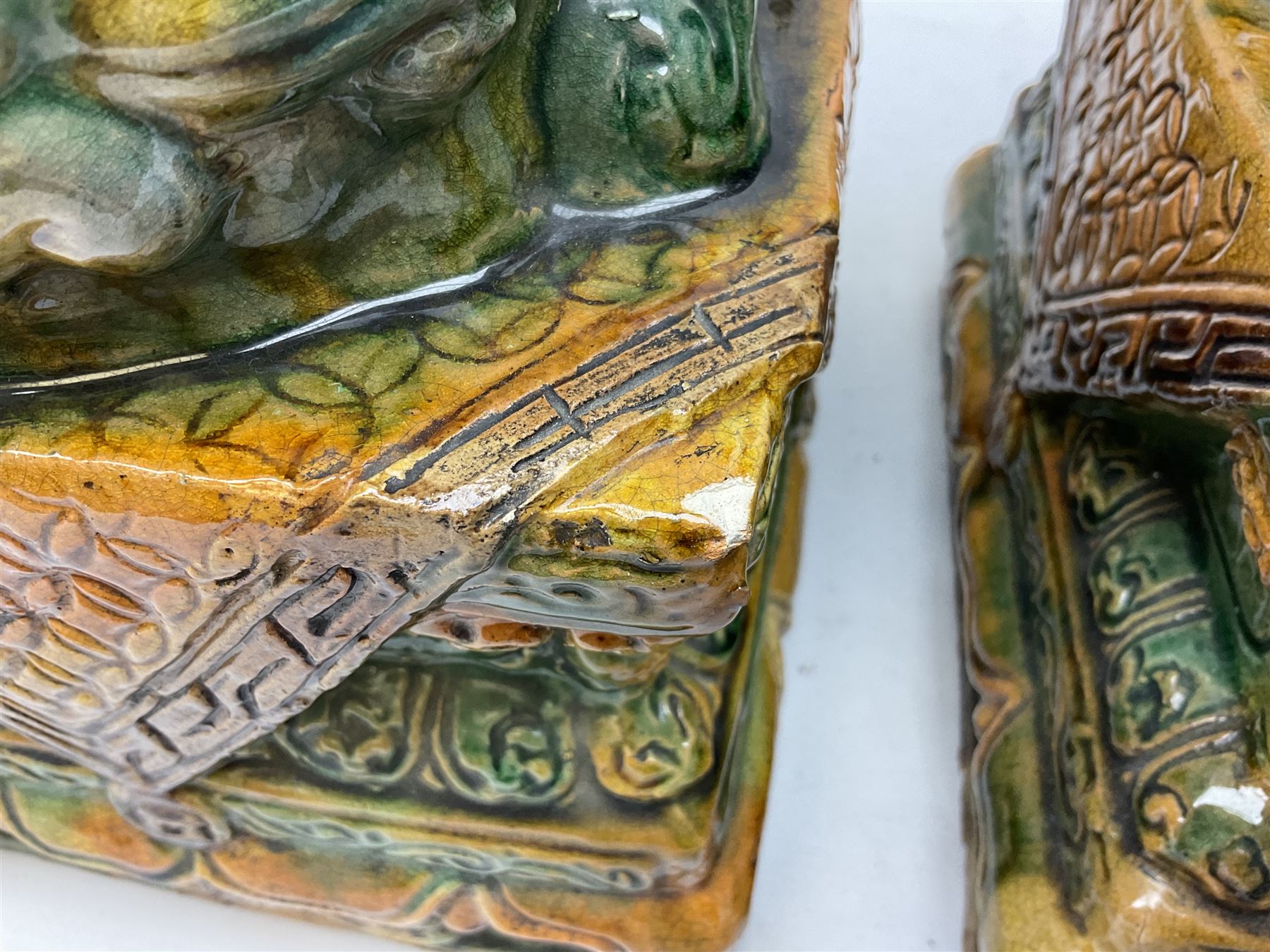 Pair of Chinese Temple Lions or Dogs of Foo, modelled in seated post, one with one front paw resting upon a ball, the other upon a cub, each upon stylised plinth base, H44cm