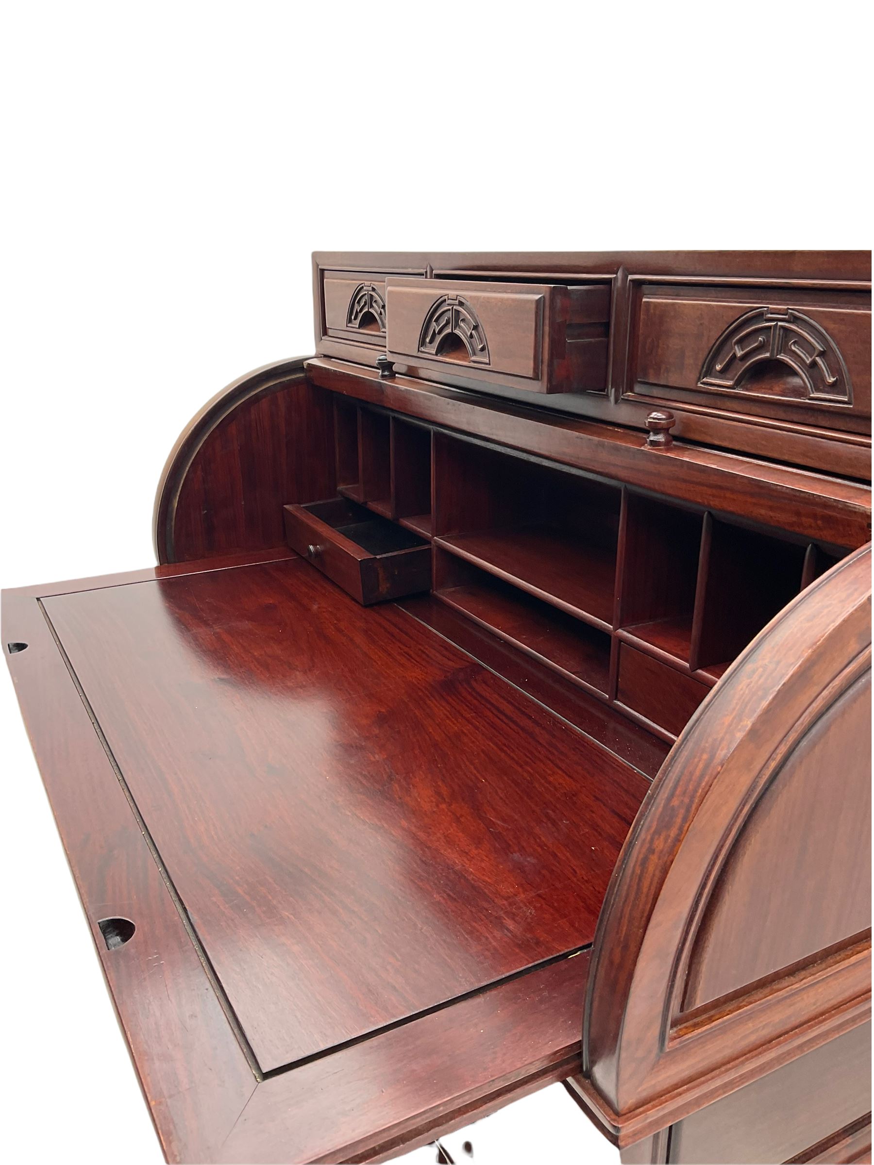 Hardwood cylinder desk, three drawers raised over curved lid, fitted interior with slide, the supports joined by undertier with fret work brackets 