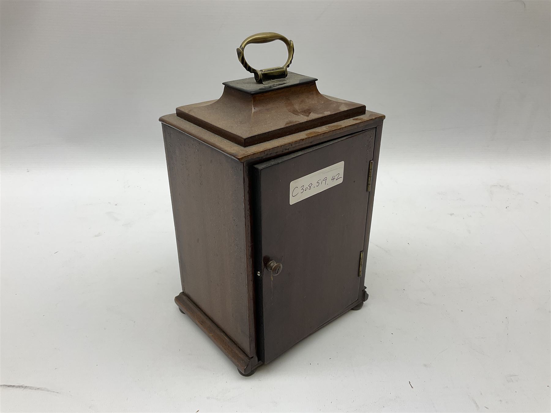 Georgian style mahogany cased bracket type clock retailed by Henry Lee & Sons Hull, with brass carrying handle to the pagoda top, arched silvered dial with Tempus Fugit plaque, raised chapter ring with Roman numerals enclosing French brass eight day movement with integral key, on bun feet, H24cm  