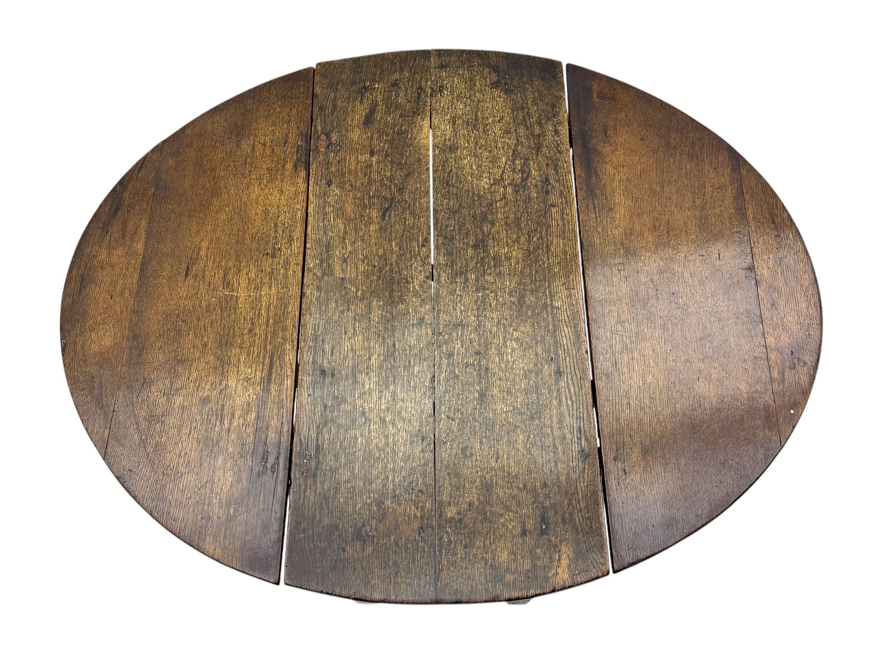 19th century oak gateleg table, the oval drop-leaf top formed of four planks, on turned column supports united by rectangular stretchers