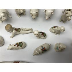 Collection of figural crested ware, to include Carlton Chins John Bull Alnwick, Clifton China Cheshire Cat,  Arcadia pig, Crafton crawling baby and another seated baby, quantity of cat, dog and pig figures, two Willow Art Model of Bunyans Statue, Toby jug, Victoria China, Arcadan bulldog, fish etc