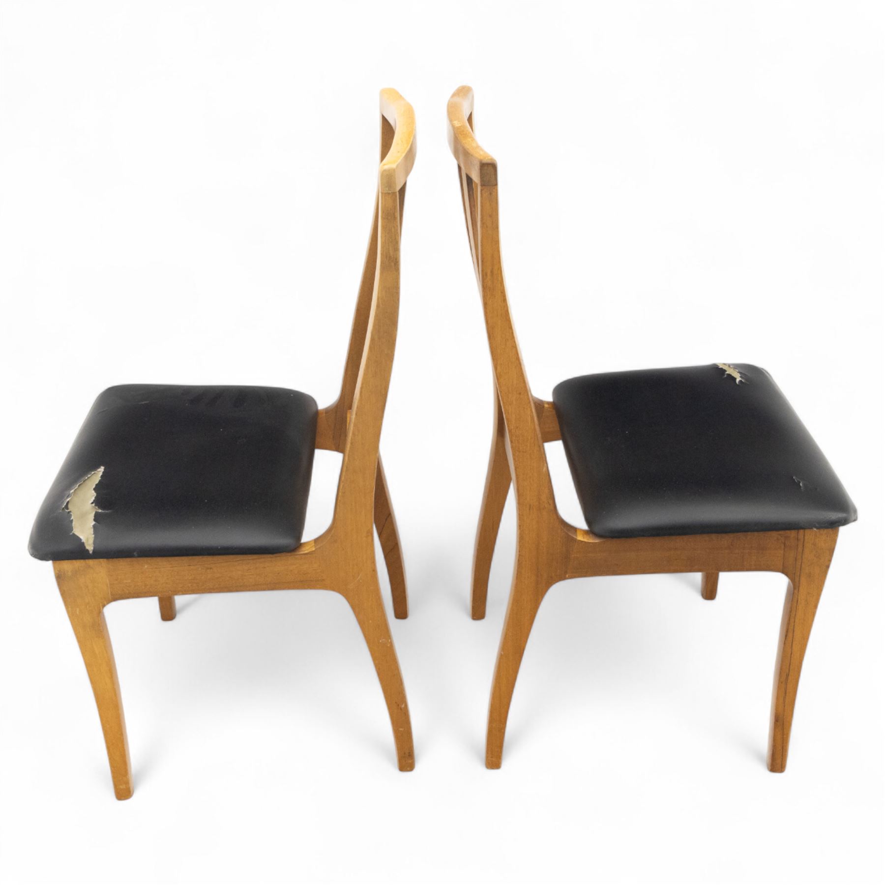 Sutcliffe of Todmorden - mid 20th century ‘S-Form’ teak dining table and chairs, the circular storable extending table with plain veneered top on tapered supports, together with matching dining chairs upholstered in black vinyl, with curved slat backs and shaped front supports, reflecting the sleek organic styling characteristic of 1960s British modern furniture design (Chairs H 93cm, W 46cm, D 46cm) (Extended 168cm)