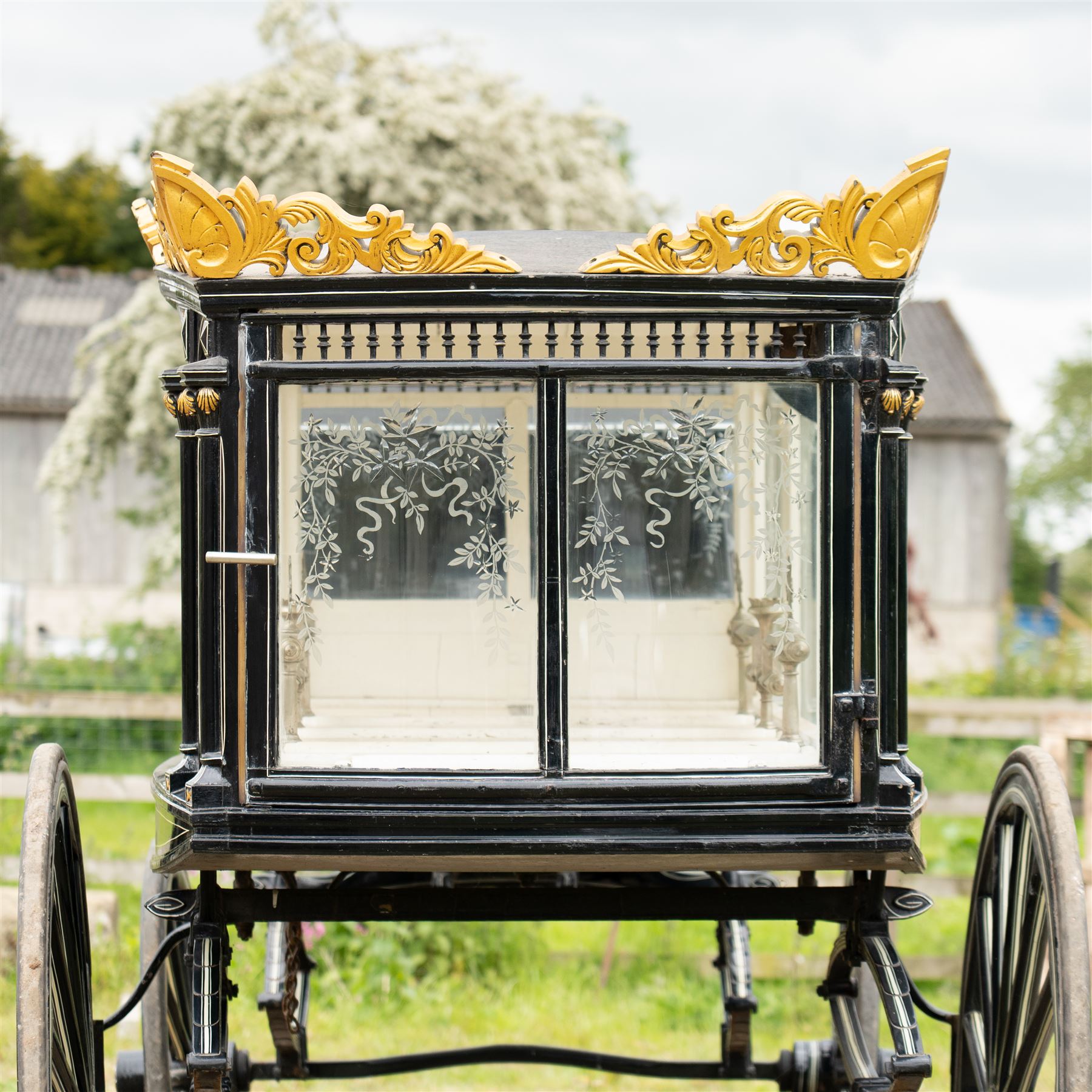 Victorian Glass Hearse

A black painted four wheeled horse drawn glass hearse with extensively glazed coffin compartment, etched glass side and end panels, decorative gilt cresting, gilt column capitals, white painted interior bier deck, metal coffin rails with cross finials, rear glazed access doors, external coachman's box seat for two, wooden spoked wheels the wheel hubs stamped 'The Economic Funeral Co', leaf spring suspension, underbody turntable steering and pole for driving with a pair of horses. The hearse has decorative painted lining throughout and an ornate black and gilt body with curved glass panels to the sides and rear.

Features

• Extensively glazed coffin compartment
• Etched glass side and end panels
• Decorative gilt cresting
• Gilt column capitals
• White painted interior bier deck
• Metal coffin rails with cross finials
• Rear glazed access doors
• External coachman's box seat
• Wooden spoked wheels
• Leaf spring suspension
• Underbody turntable steering
• Pole for driving with a pair of horses
• Decorative painted lining

Dimensions:
Overall length: 406 cm
Body length: 250 cm
Overall width: 190 cm
Body width: 115 cm
Height: 228 cm

Wheel Diameters:
Front wheels: 102 cm
Rear wheels: 133 cm

Seating

Coachman's box seat: 2