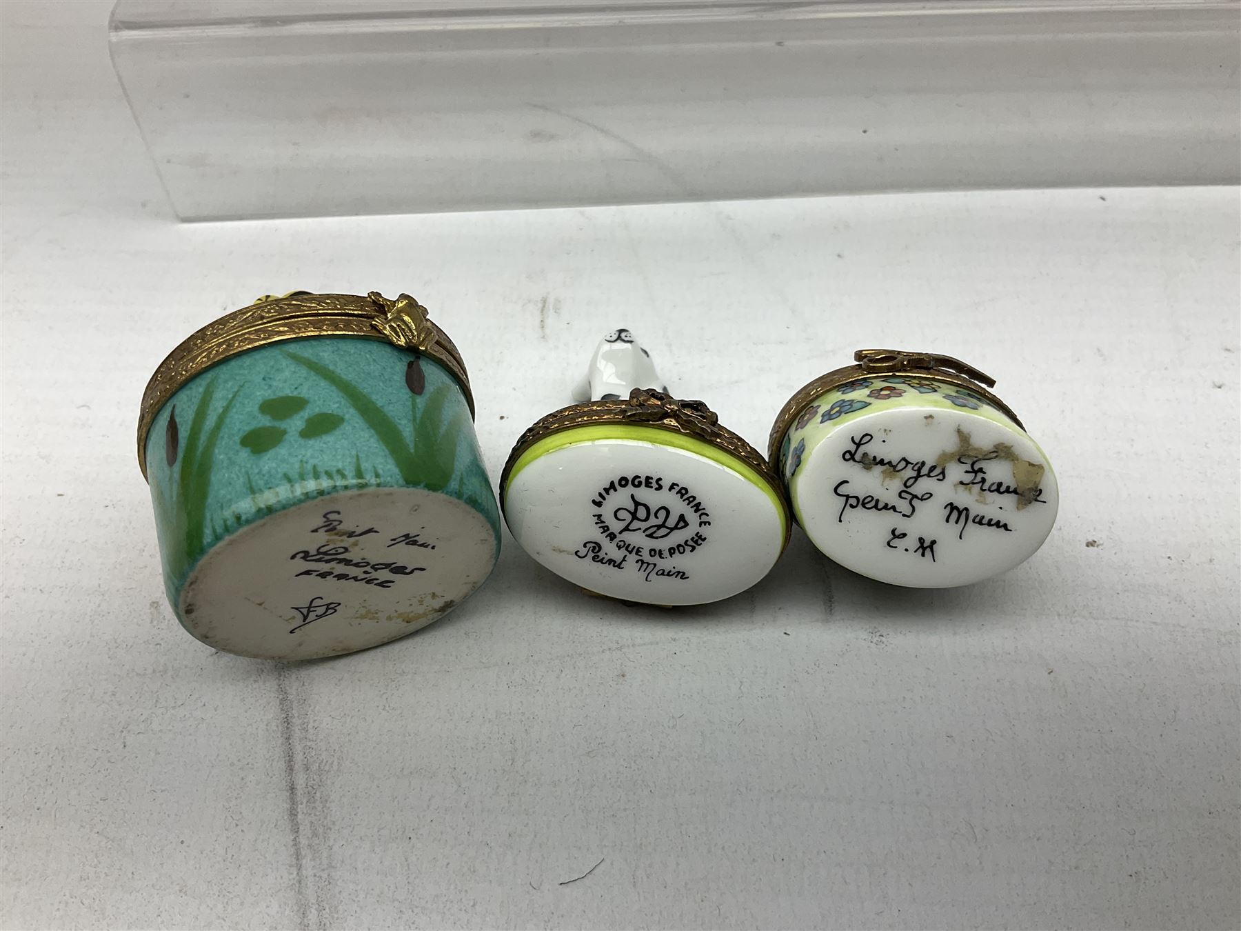 Group of Limoges trinket boxes, to include a number of novelty examples, including examples modelled as Noah's ark, shotgun case containing shotguns, picnic basket containing food, toad reading book seated upon a lily pad, etc., (9)