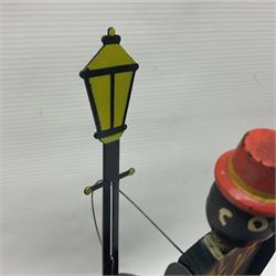 Early 20th century National Co. ‘Microphone Dancing Sam’ battery operated American toy; comprising black wooden dancing figure with articulated limbs and mouth, hooked onto a metal lamp post attached to the battery operated speaker base, with original microphone, H31cm 