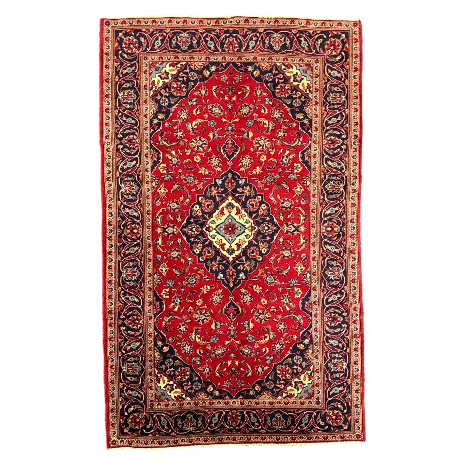 Central Persian Kashan rug, crimson ground with central medallion with  quarter medallions in each corner and decorated with floral sprays and palmettes, dark blue main border with repeating palmette and vine pattern   framed by small guard border with floral meanders 