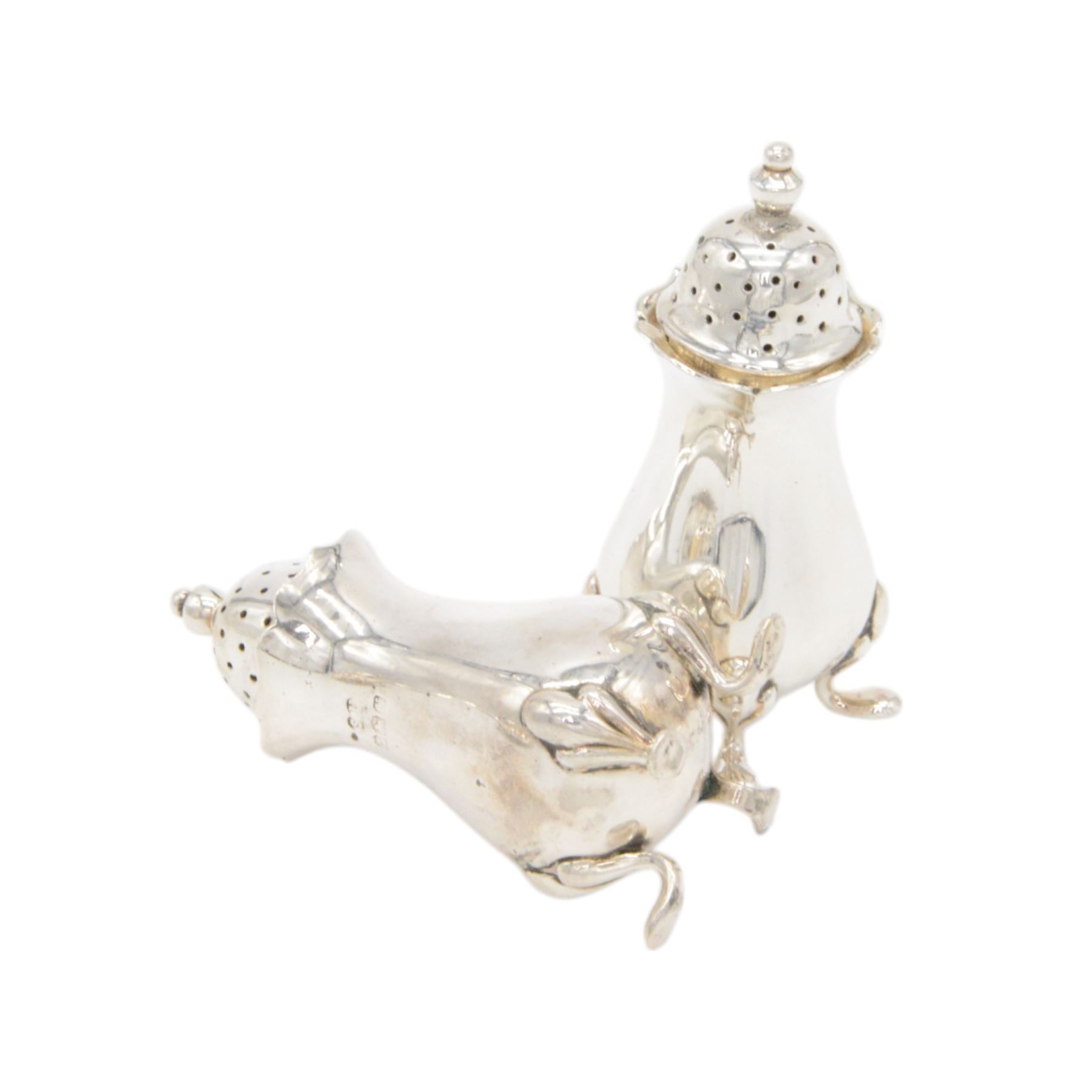 1920s silver five piece cruet set, comprising two pepper shakers, two open salts and a mustard pot, all of oval form and upon four pad feet, hallmarked William Suckling Ltd, Birmingham 1923