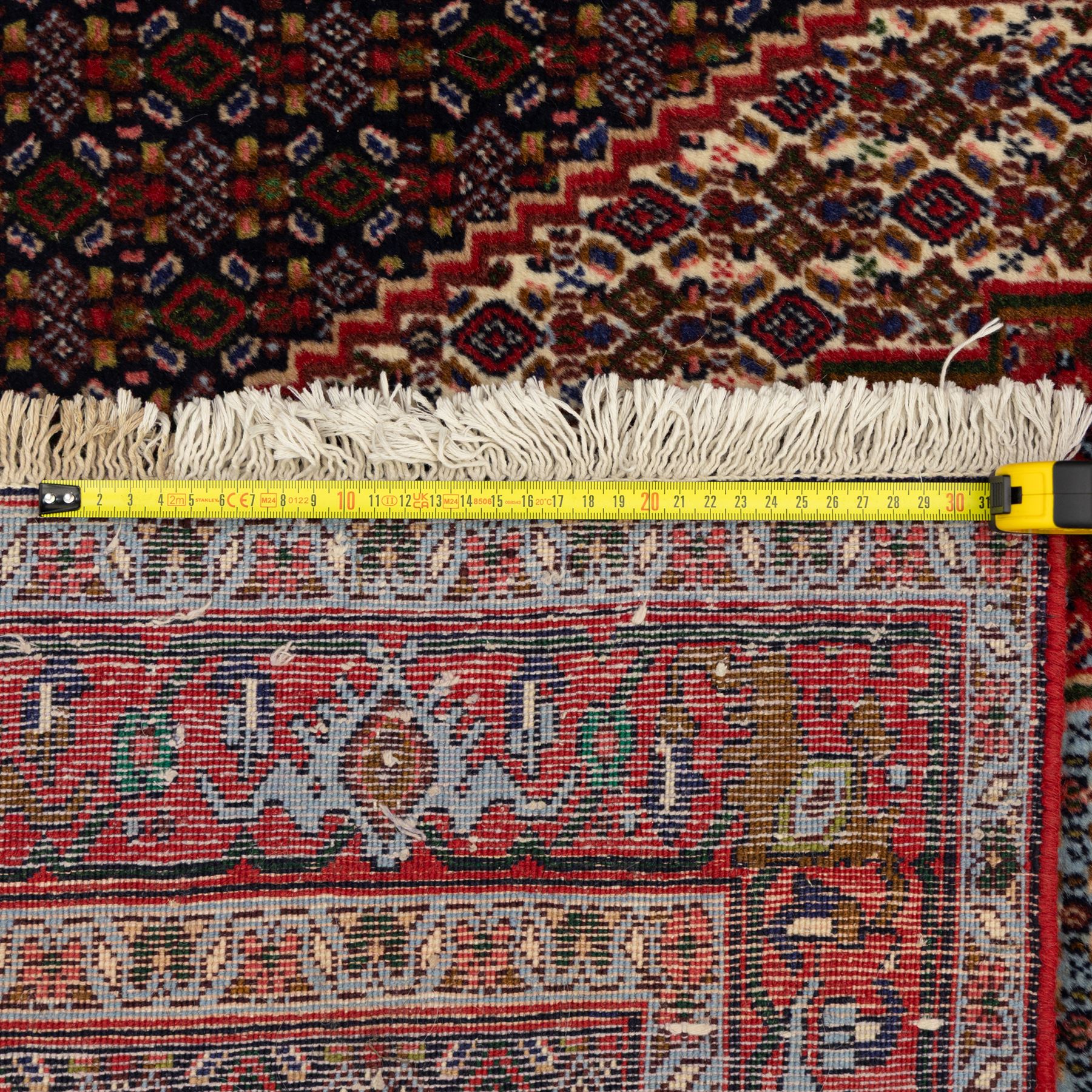 Persian Ardakan rug, featuring central elongated diamond medallion with serrated edges on a repeat boteh field, framed by triple guard borders with red floral scroll design