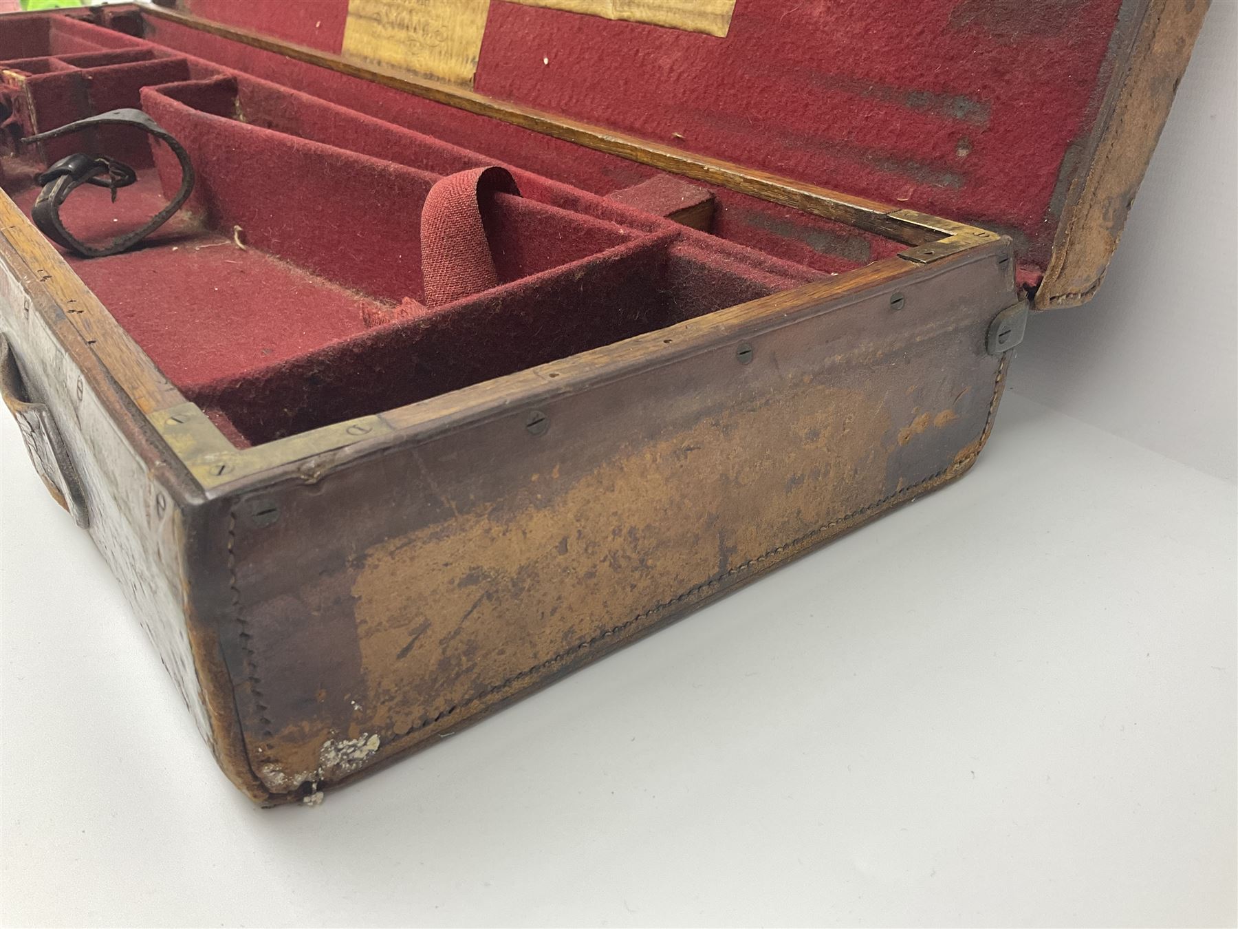 Leather shotgun case, the red baize lined interior with the trade labels of Westley Richards & Co., London, a brass plaque inscribed 'T Nevin, Mirfield, Yorkshire' to cover, with key, case to fit barrel 76cm (30 inches)  
