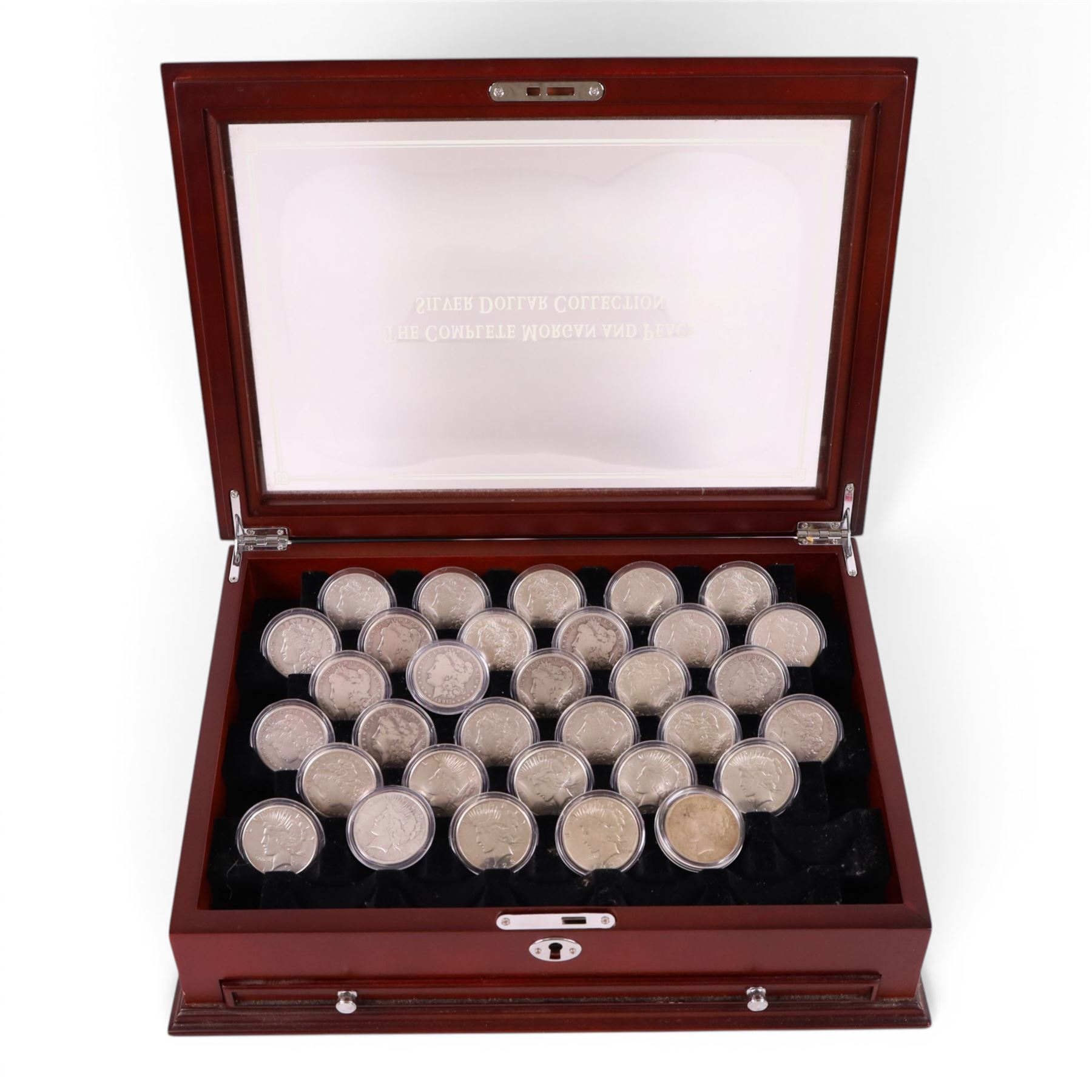 Thirty-two United States of America silver one dollar coins, comprising twenty-three 'Morgan' dollars and nine 'Peace' dollars, presented as 'The Complete Morgan and Peace Silver Dollar Collection', in display case