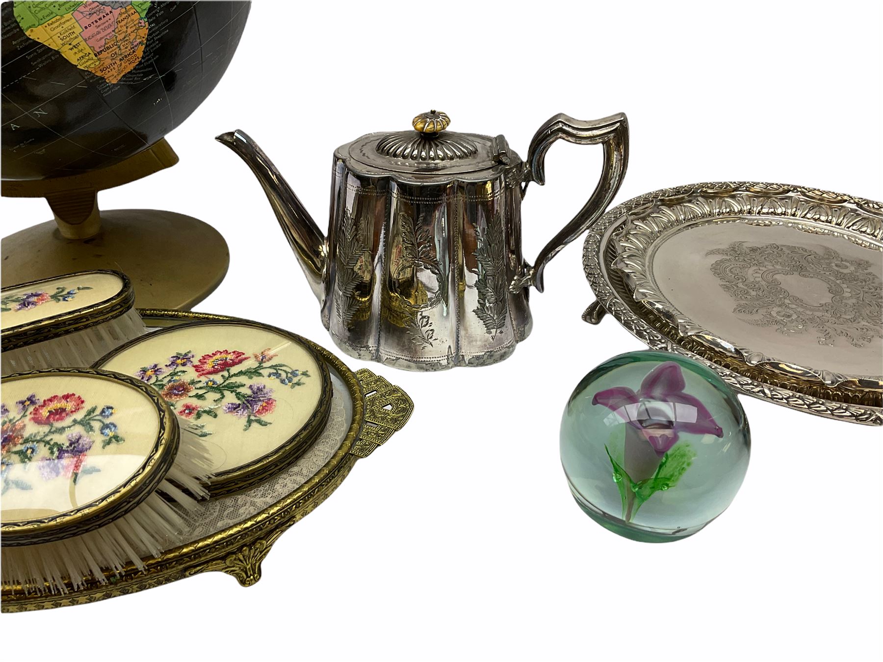 ladies vanity set with floral embroidery backs, comprising mirror, two brushes, comb and tray, along with paperweight with internal floral design, brass and copper bedwarmer, two metal serving trays, a metal teapot and a globe. 