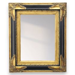 19th century design rectangular wall mirror, set within a swept giltwood and gesso frame, with foliate corner mounts and ebonised inner border, enclosing a bevelled mirror plate