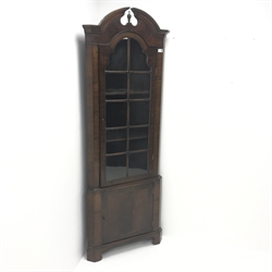  20th century walnut corner cabinet, arched swan neck pediment with central finial, single glazed door, two shelves, cupboard door, shaped bracket supports, W69cm, H191cm, D38cm  