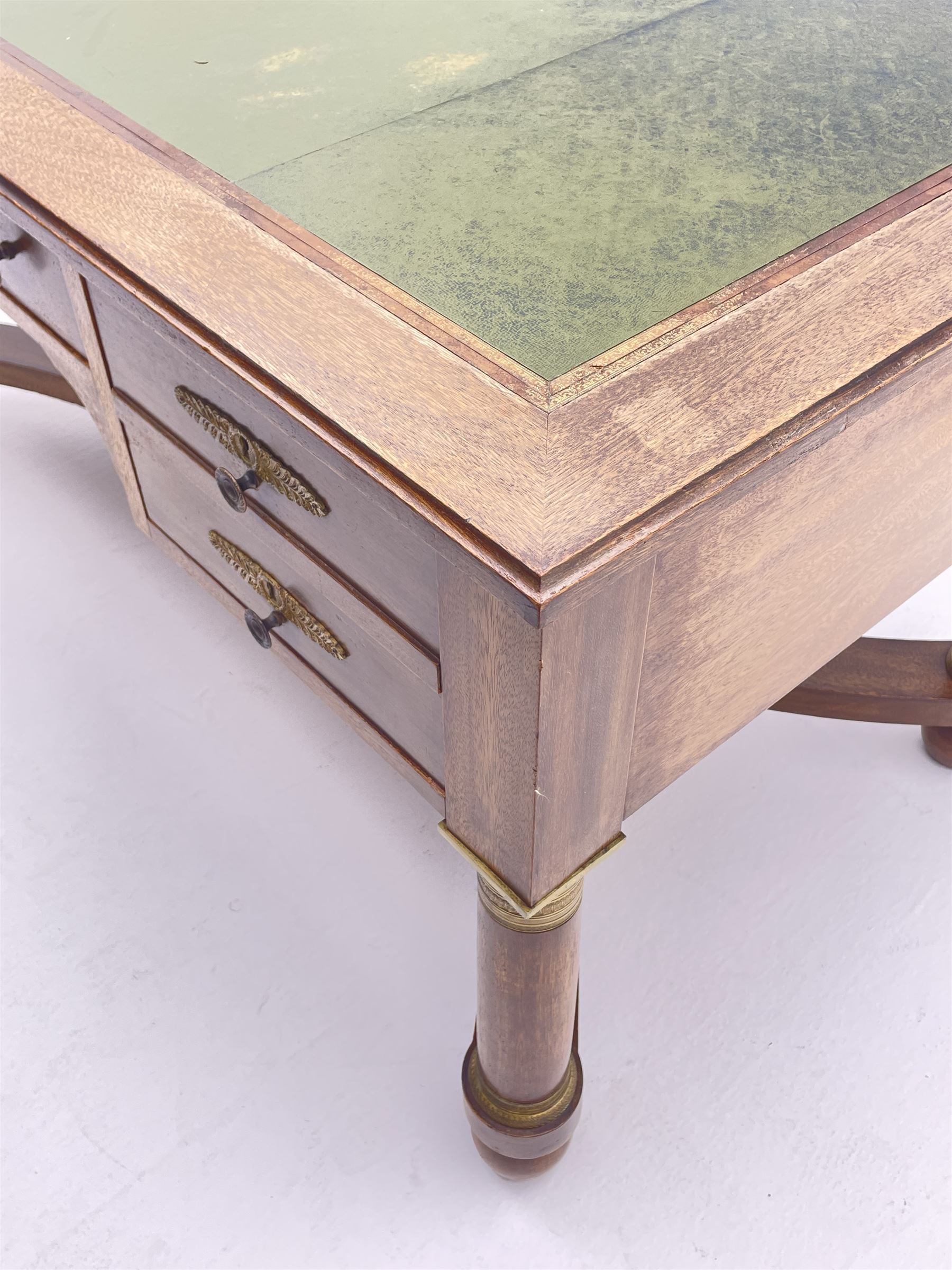 French Empire style walnut desk, moulded rectangular top with inset leather, two leather inset slides either side, fitted with four drawers, turned supports joined by curved x-shaped stretchers, gilt metal mounts 