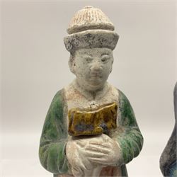 Three Chinese terracotta court attendant tomb figures, probably Ming Dynasty, two examples decorated in Sancai green glaze, the third example decorated in two tone blue glaze, each upon stepped square bases, tallest H22.7cm