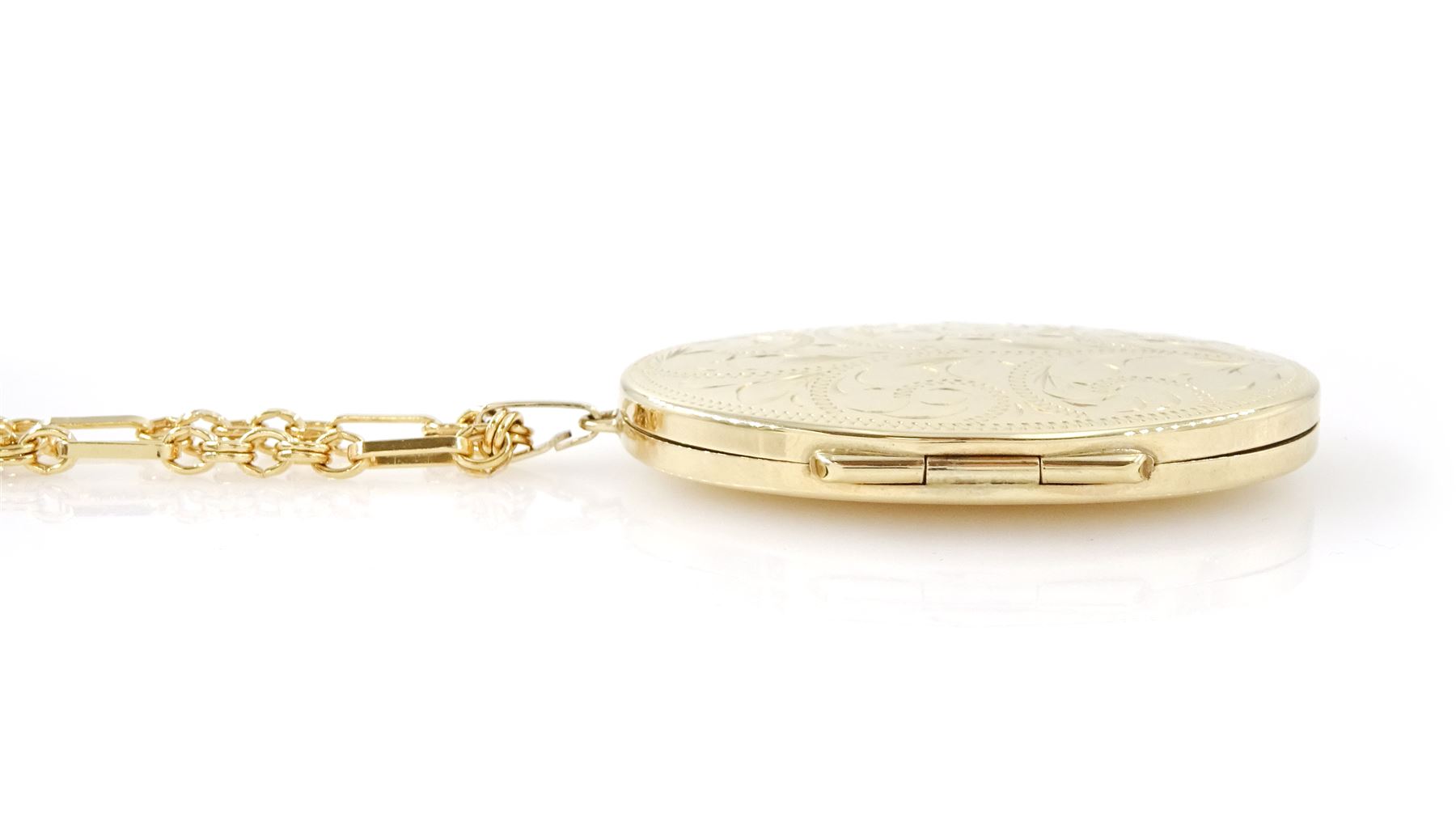 Gold oval locket with engraved decoration, on a gold fancy link chain, both 9ct, hallmarked 