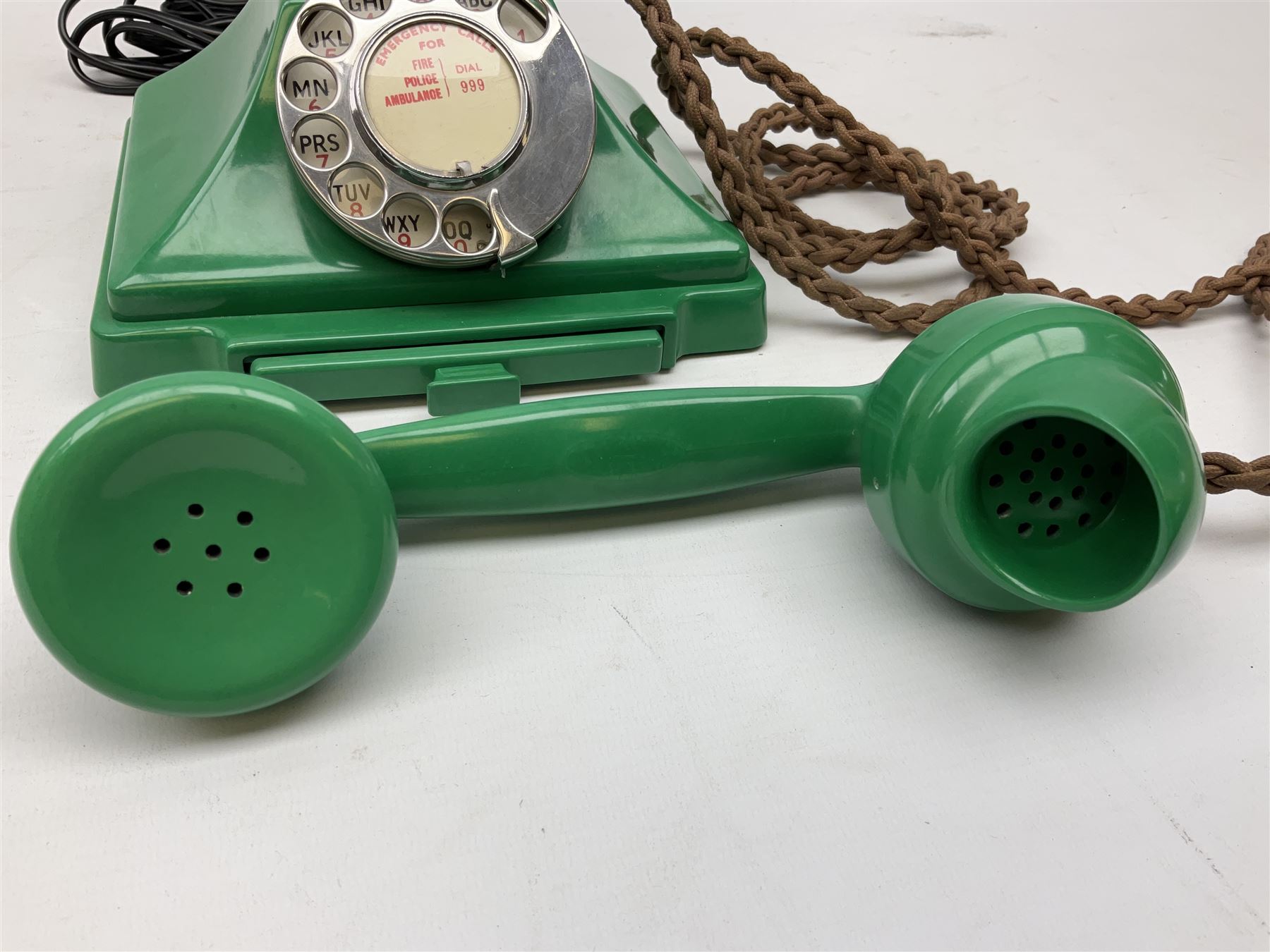 Jade green Bakelite telephone, of pyramid form with alphabet dial, brown braided handset cord and a base draw