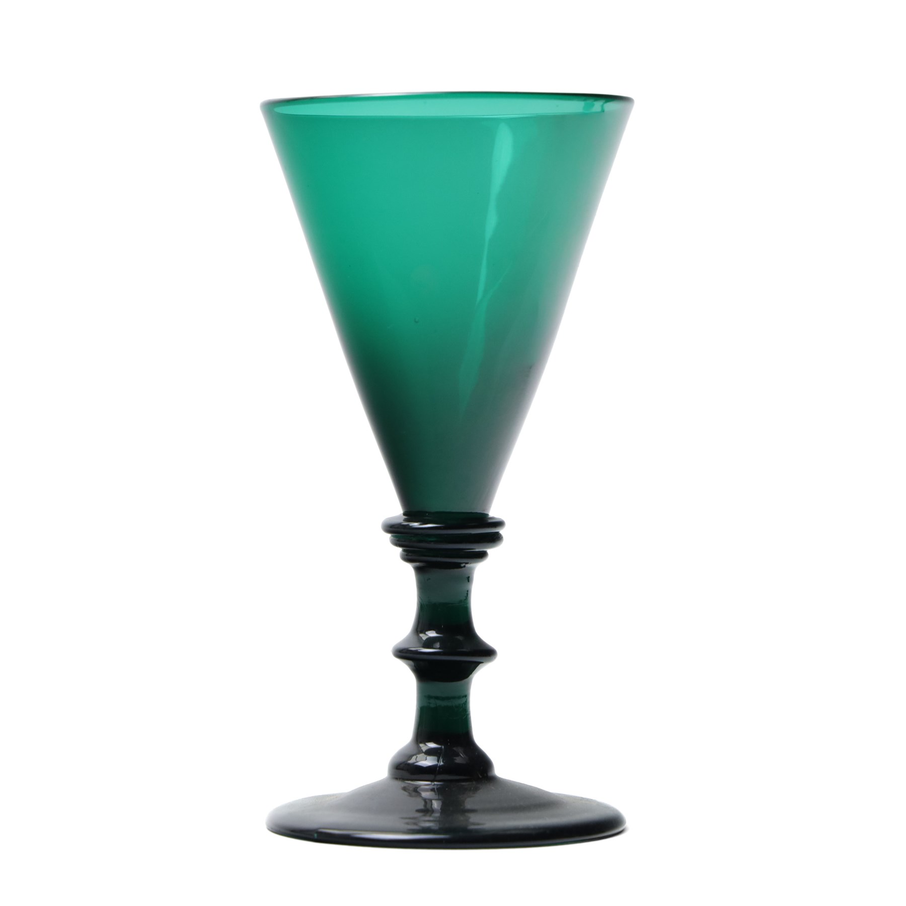 Five green wine glasses of early 19th century design with conical bowls and double knop stems on a circular foot, with pontil marks, pair of green wine glasses with chamfered stems together with an Asprey catalogue of green glass 1740-1840 and two pieces of glass fruit and leaves