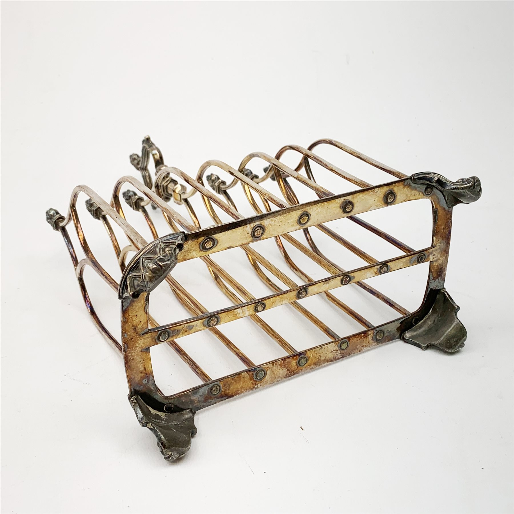 Victorian electroplate Gothic style toast rack, with seven arched bars, openwork handle and arcaded bracket feet, marks for John Gilbert, H25cm   