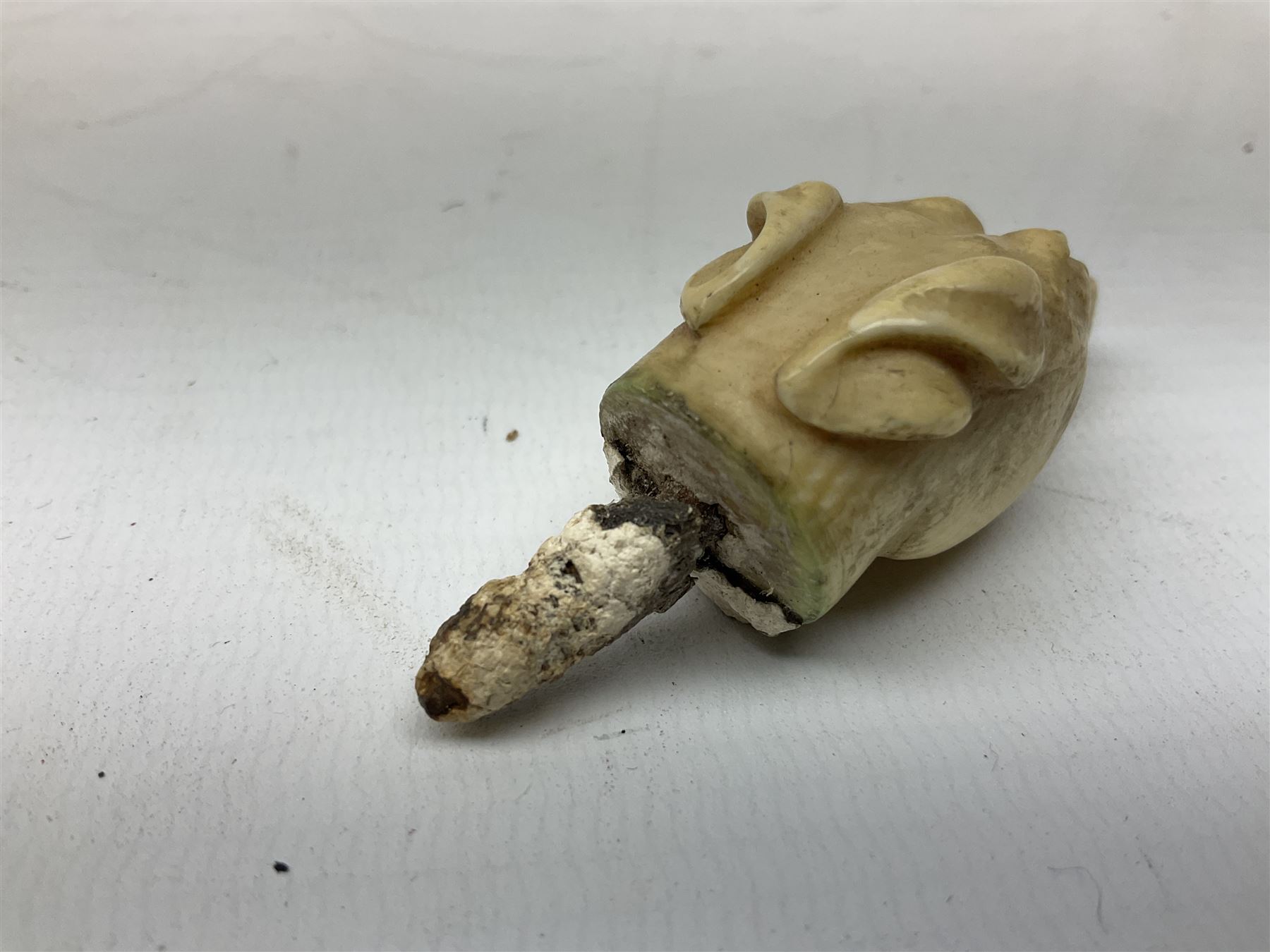 19th century carved ivory walking cane handle, modelled as the head of a greyhound with inset glass eyes, together with a further 19th century ivory example, modelled as a caricature of a gentleman's head, (2)