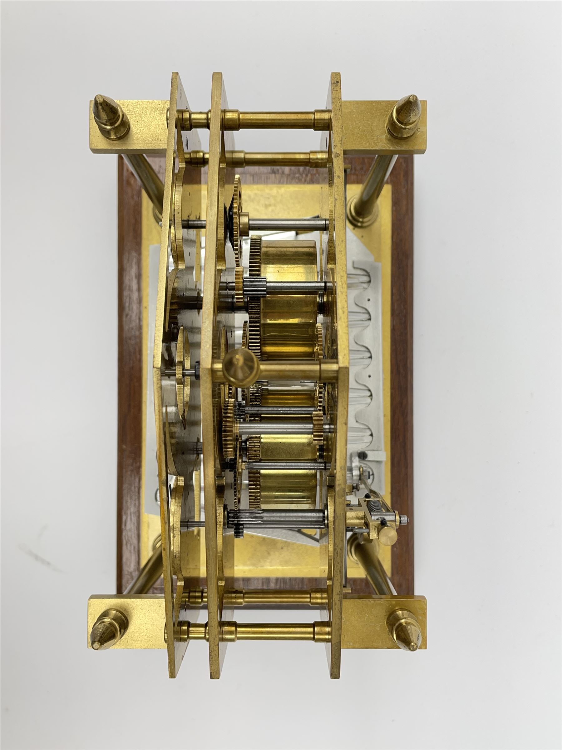 Mid 20th century 'Congreve' rolling ball clock, sloped arch and pierced brass movement, the central Arabic minute chapter ring flanked by hour and seconds dials, twin train driven eight day movement, raised on mahogany plinth with turned brass feet, under acrylic cover