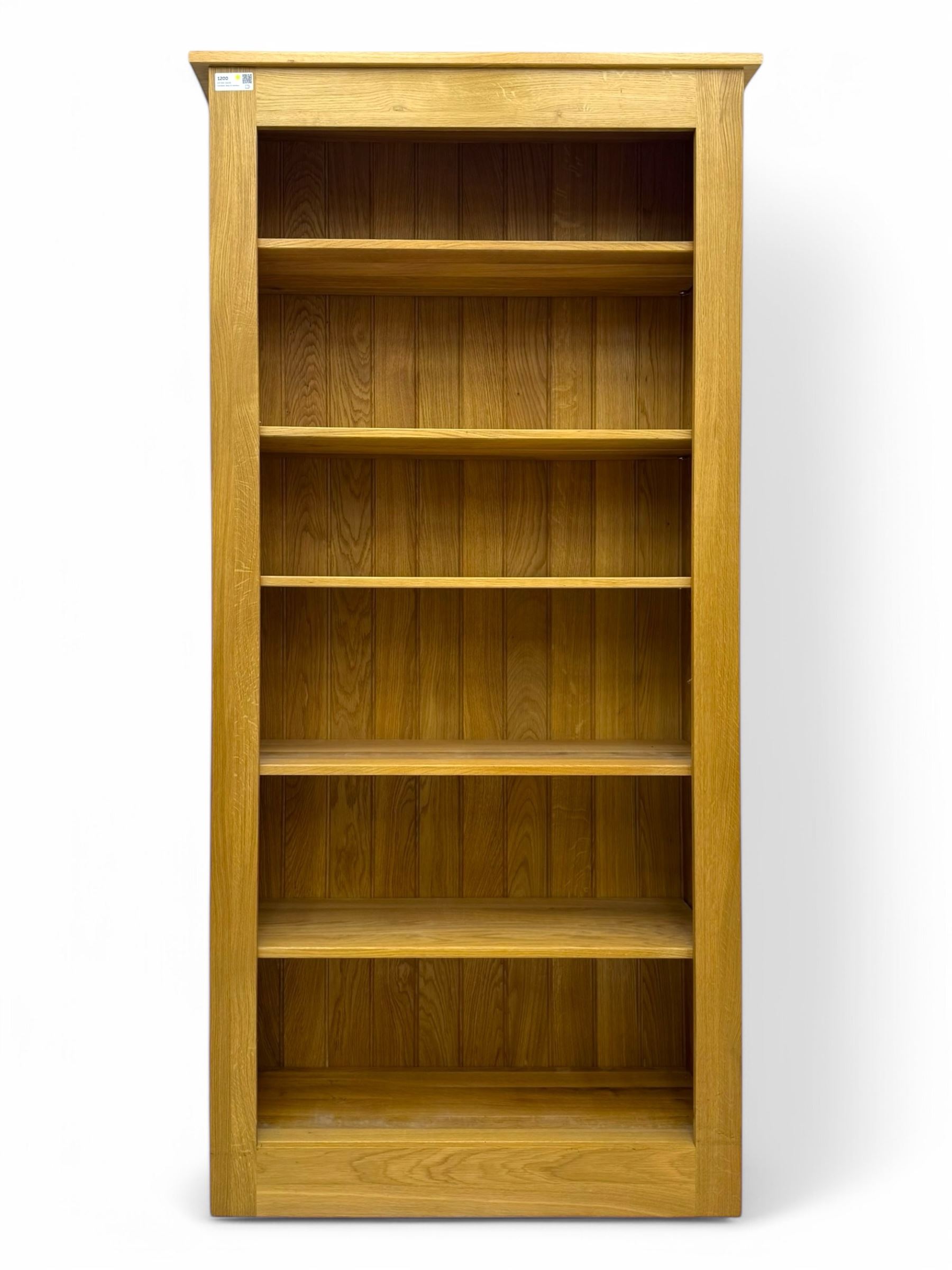 Contemporary light oak open bookcase, rectangular form with projecting top, fitted with five adjustable shelves, on a straight plinth base