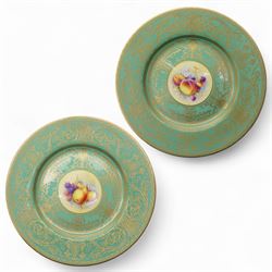 Pair of Royal Worcester cabinet plates painted with central panel of fruit by Peter Platt signed 'P Platt' within a green and gilt surround D27cm