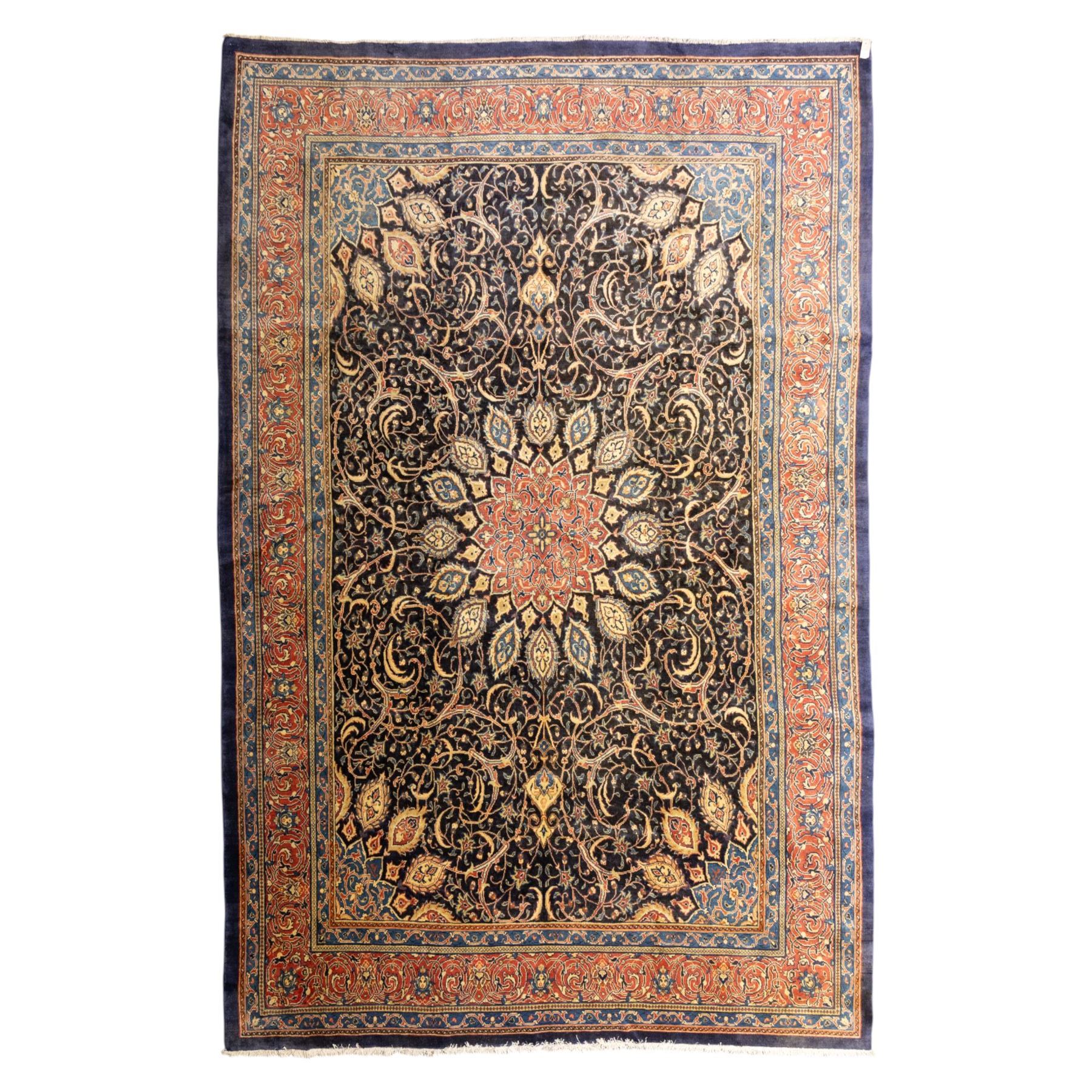 Large North West Persian Mahal hand-knotted carpet, central indigo field with a rosette medallion with an all-over design of scrolling vines and palmettes, framed by a brick red border of arabesques and flowerheads between sky blue and ivory guard stripes, with cotton fringe ends 