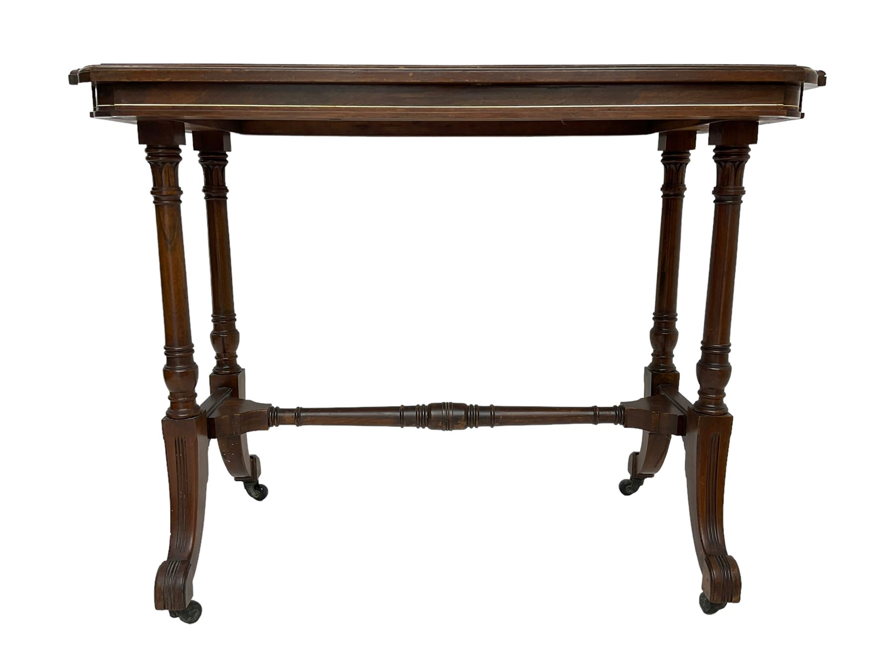 Late Victorian rosewood stretcher table, the rectangular top with curved canted cornice and moulded edge, on quadruple turned pillar supports carved with foliage, joined by collar turned stretcher, on splayed moulded supports with brass and ceramic castors