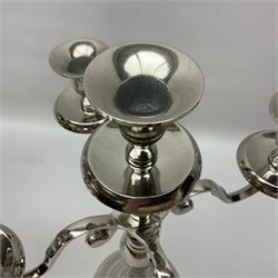 Pair of four branch candelabras, urn-shaped nozzles raised upon scroll branches supported from tapering central stem, with a stepped circular base, H40cm