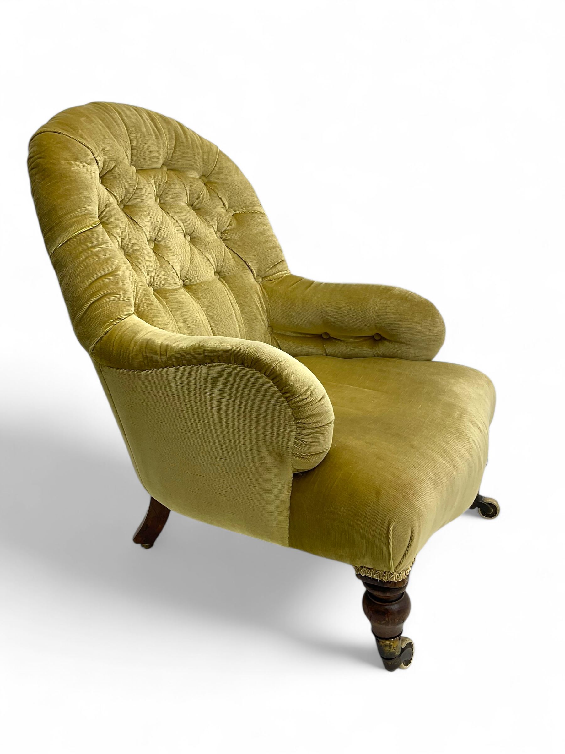 Late 19th century button-back nursing chair, upholstered in olive-green velvet, shaped back with padded arms, raised on turned front supports terminating in castors