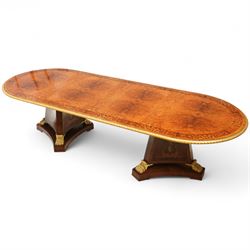 Arthur Brett & Sons - late 20th century twin pedestal dining table in the Second Empire style, the oval Amboyna burl veneered top, bordered with tulipwood crossbanding and delicate floral marquetry inlay, and rosewood crossbanded outer border within gilt gadrooned edge, over two mahogany triform pedestal bases with rosewood crossbanding and decorated with neoclassical marquetry of tied ribbons, leafy sprays, and scrolling acanthus decoration, raised on carved and gilded lion paw terminals on plinth bases, underside with maker's label