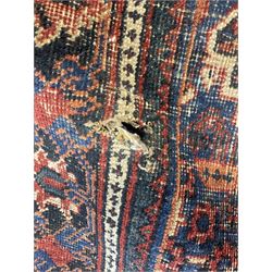 Persian Hamadan red ground rug, the field decorated with floral motifs with central lozenge medallion, guarded border decorated with repeating stylised plant motifs