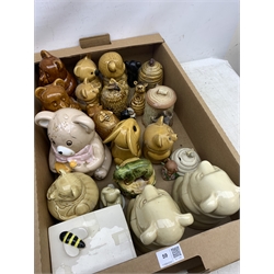 A large collection of various ceramic honey pots, to include examples in the form of bee skeps, etc.