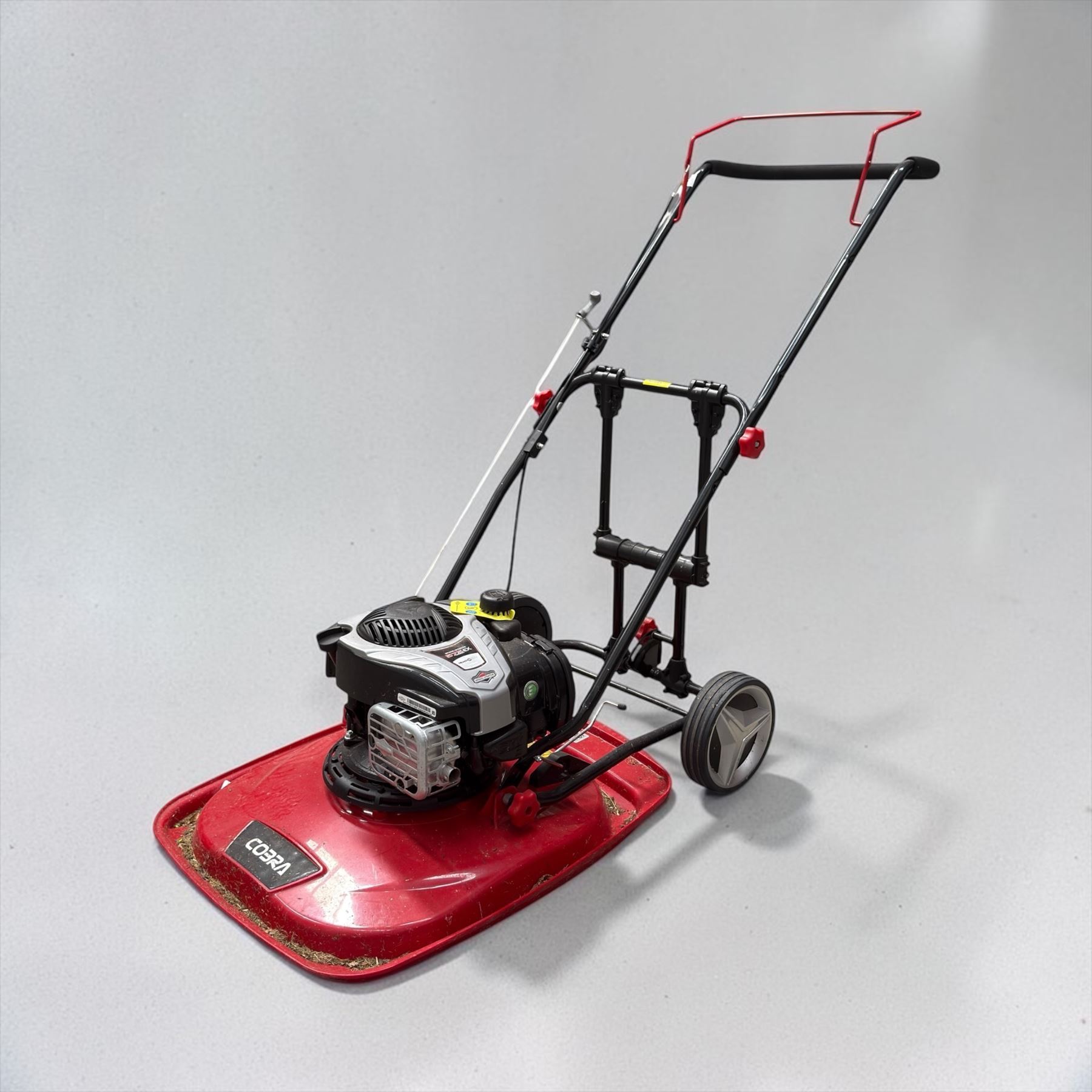 Cobra-  575ex petrol hover mower, with Briggs & Stratton engine, wheeled transport frame and red deck.