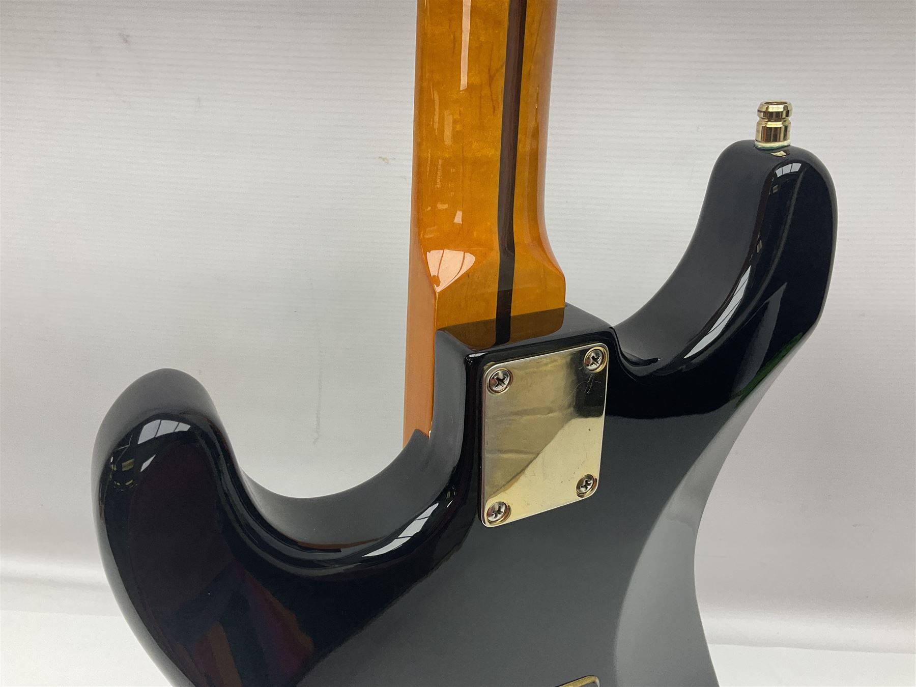 Copy of a Fender Stratocaster electric guitar in black with Wilkinson bridge, lock-in tuners, synchronised tremolo and various patent numbers; L99cm; in hard carrying case with strap and digital tuner