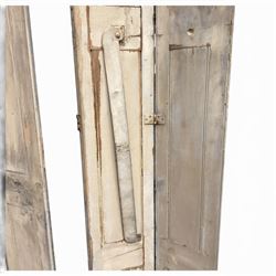 Set of three French 19th century painted pine folding window shutters of tall form, each comprising two hinged leaves with three graduated raised and fielded panels, in antique cream-painted finish