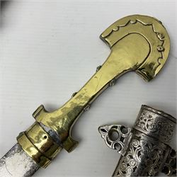Moroccan jambiya dagger with 24.5cm plain curved blade stamped LONDON to the ricasso area, the hilt and scabbard overlaid with plain sheet brass to the back and ornate silver coloured metal to the front; waisted grip and arched pommel; two pyramid mounts to the scabbard L41cm overall; large billhook with curving blade and stacked leather washer grip; and a reproduction halberd blade (3)