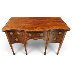 George III inlaid mahogany serpentine sideboard, the shaped top with crossbanding and satinwood stringing, fitted with central bow-front cock-beaded frieze drawer over a shaped apron inlaid with paterae, shell motifs and scrolling foliage, flanked by a deep right-hand drawer and two drawers to the left, raised on square tapering supports with spade feet