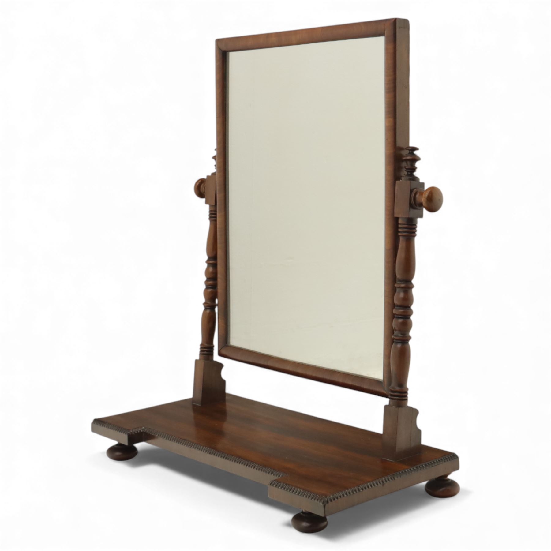 Two early 20th century mahogany swing dressing mirrors, comprising one with arched rectangular plate in a moulded frame on shaped supports, flanked by two inlaid trinket drawers (H 69cm, W 88cm, D 20cm), together with another rectangular plate mirror on turned supports upon bun feet (H 58cm, W 48cm, D 23cm)