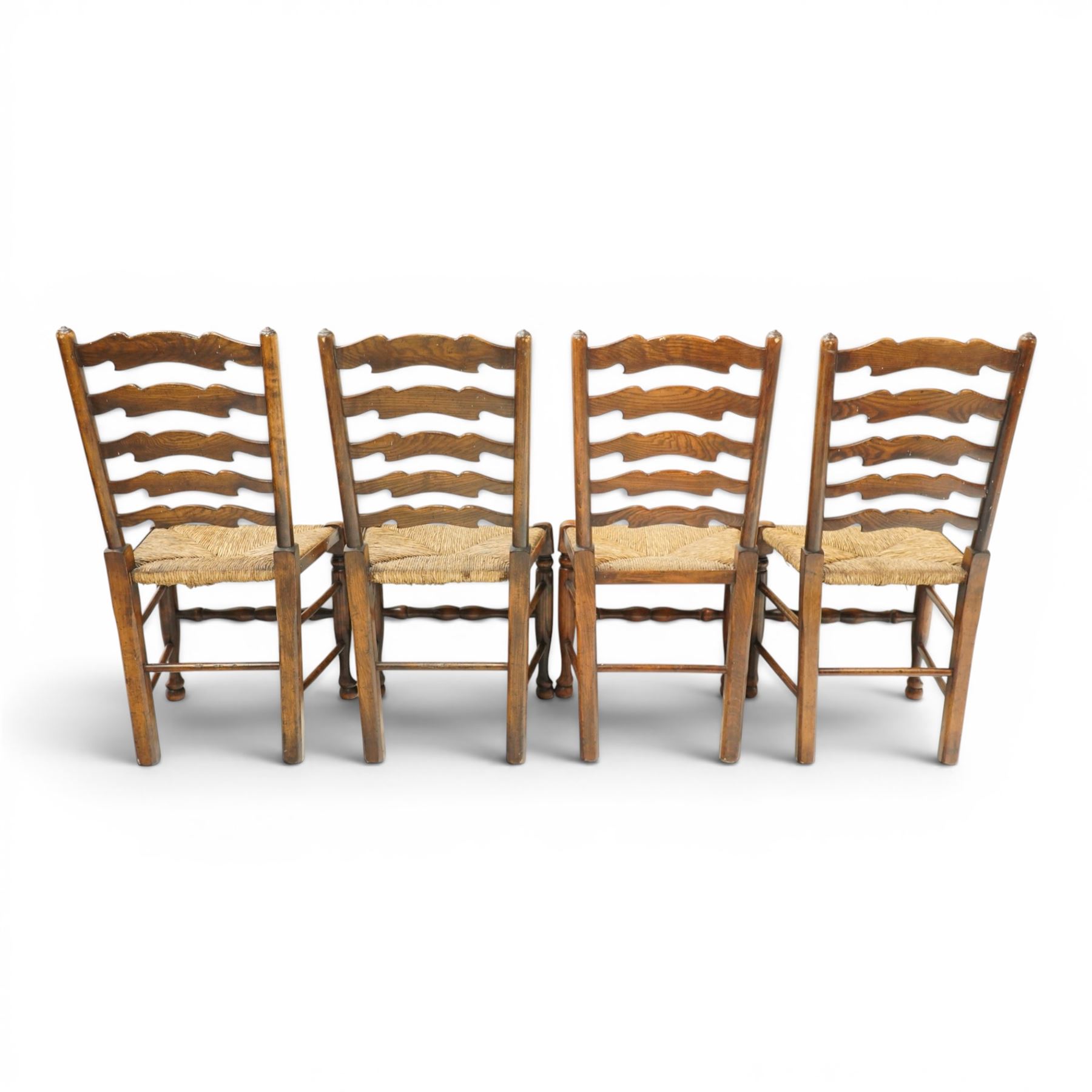 Set of eight country ladderback chairs (6+2), shaped ladderback over a rush seat, raised on turned supports, united by stretchers