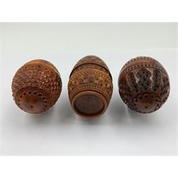 Three 19th century coquilla nut pomanders or flea catchers, two of egg shaped form and the third of barrel from with carved and pierced decoration and screw threaded join, largest H8cm